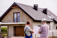 Architekt mit Sanierungsplan vor einem sanierungsbedürftigen Haus – energieFranke in Bayern, Thüringen und Sachsen